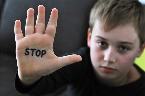 photo small abused boy holding his hand with the word stop written on it concept of domestic violence